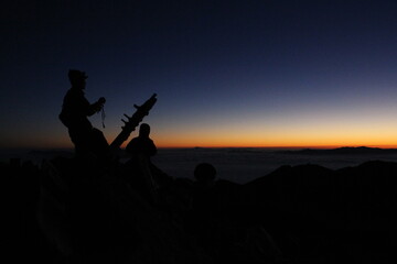 Fototapeta na wymiar 山頂で日の出を待つ登山者