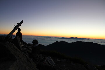 山頂で日の出を待つ登山者