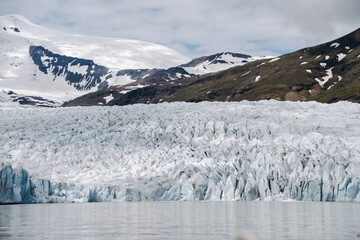 View of the glacier tongue Fjallsjökull with its icebergs and the glacier lagoon Fjallsárlón in Iceland. With a view of Öræfajökull in the background.