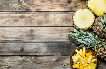 Obraz na płótnie Canvas Slices of pineapple in a bowl and fresh pineapple.