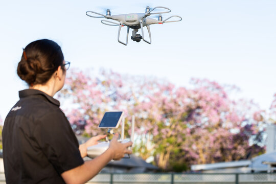 Businesswoman flying RPA drone in suburban area