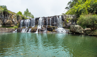 Obraz premium Close up of waterfall with swimming area.