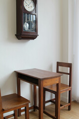 Wooden table and chair by the white concrete wall