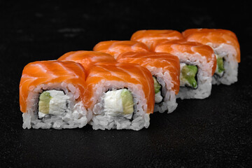 salmon sushi roll on black background