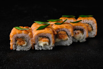 Baked salmon sushi roll on black background