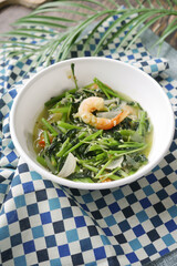 Top view of bowl with cooked spinach on table 