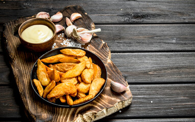 Baked potato slices with sauce and garlic.