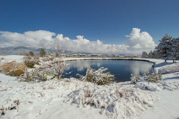 unfrozen round lake in winter