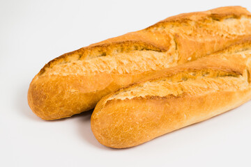 French baguettes on a white background with copy space. Delicious appetizing crust of a bun close-up