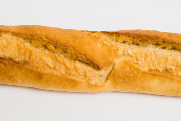 French baguette on a white background with copy space. Delicious appetizing crust of a bun close-up