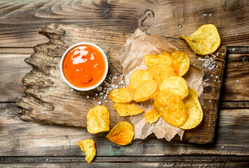 Potato chips on old paper with tomato sauce.