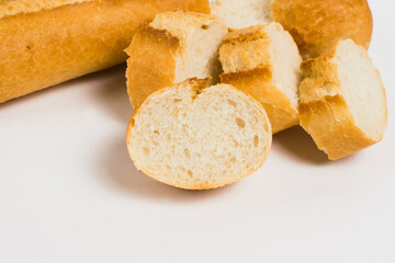 Delicious french baguette close-up on a white background. Pieces of French bread with an appetizing crust macro.