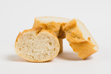 Pieces of French bread, baguette with an appetizing crust, on a white background, macro.