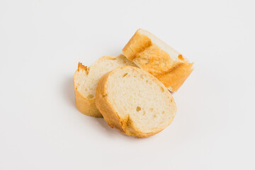Pieces of French bread, baguette with an appetizing crust, on a white background, macro.