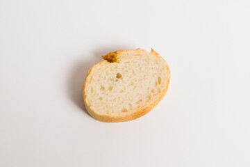 A piece of baguette with an appetizing crust, on a white background, macro. Concept of healthy...