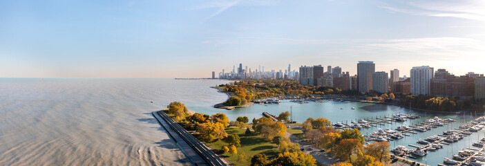 Aerial panorama overlooking Belmont harbor peninsula and the Lakeview neighborhood with the Chicago skyline in the distance.