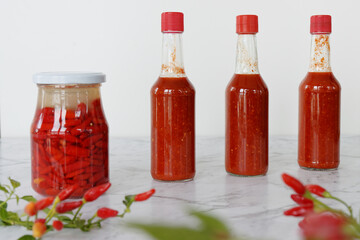 Hot sauce made from fermented fresh Tabasco chili peppers. Jar with fermentation process and ready...