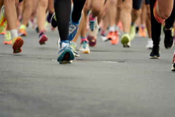 Fototapeta premium Marathon running race, people feet on city road.