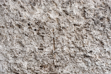 Surface of a basalt wall with roughness and irregularities for use as an abstract background and texture.