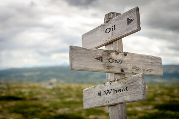 oil gas wheat text quote on wooden signpost outdoors in nature.