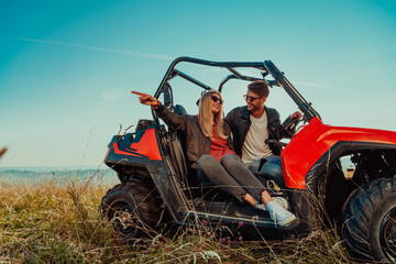 Young happy excited couple enjoying beautiful sunny day while driving a off road buggy car on mountain nature © .shock
