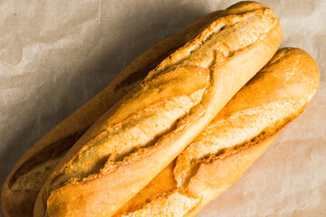 Delicious baguettes close-up, on baking paper. Concept of development of craft bakeries