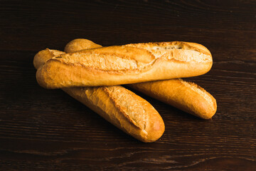 French baguettes with appetizing crusts on a wooden background close-up