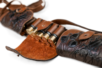 Old hunting cartridges and bandoleer on a wooden table