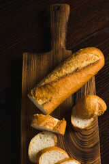 Appetizing baguette with butter on a wooden cutting board, flatlay