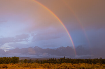 Fototapeta na wymiar Storm Clouds and Rainbow over the Tetons in Autumn