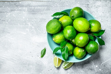 Fresh juicy lime with leaves on a plate.