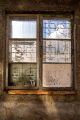 an old window with cracked paint and glass with tiles of squares of texture and a lattice