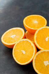 Orange slices on a black background. Halves of juicy oranges for a healthy diet