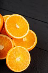 Bright halves of oranges on a wooden table. Halves of juicy oranges on black boards