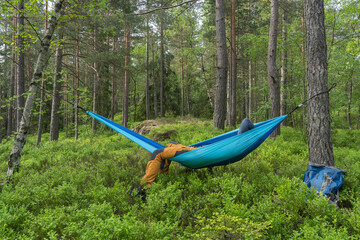 Obraz na płótnie Canvas Hiker sleeping in a hammock between trees.