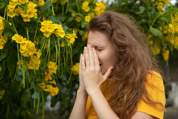 Portrait of beautiful young allergic woman is suffering from pollen allergy or cold on natural...