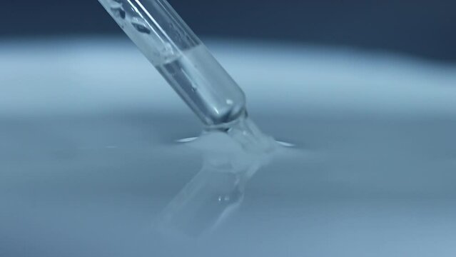 Close up macro of pipette with serum liquid drop
