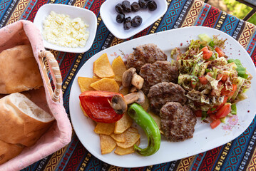 Typical Turkish meal of Kofte with green pepper, mushroom, salad and French fries.