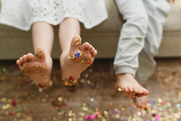 Children's bare feet with confetti on their feet