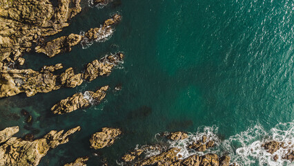 Ocean meets jagged cliff