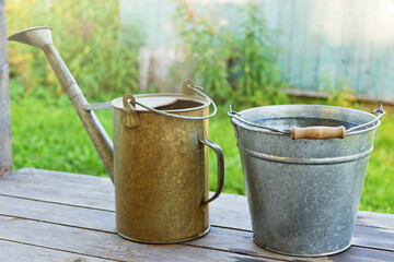 Metal bucket with water and watering-pot