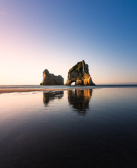 Einsamer Strand mit Felsformation bei schönem Licht  in Neuseeland.