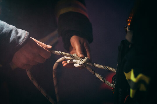 Firefighter tightening a knot.
