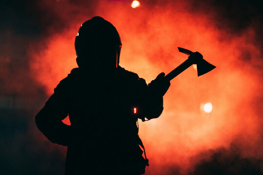 firefighter holding an axe in a red smoke