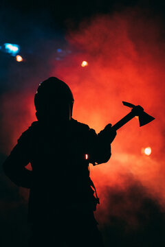 firefighter holding an axe in a red smoke