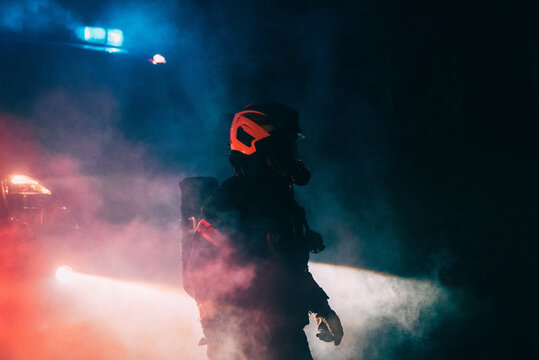 Firefighter in smoke in front of a firetruck.