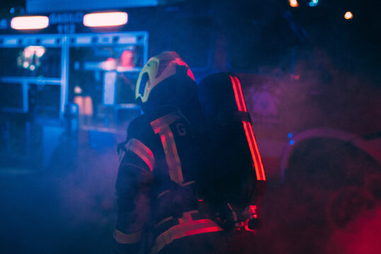 A firefighter taking equipment surrounded with a smoke.