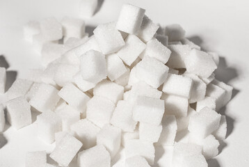 Fototapeta na wymiar Refined sugar cubes blocks lumps pieces in pile, heap. Overconsumption of sugary products, unhealthy food concept