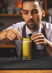 Portrait of barman adding ingredients