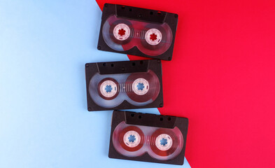 Three audio cassettes on a blue-red background